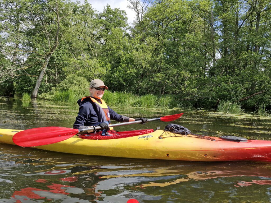 Kajak i en å med træer som baggrund